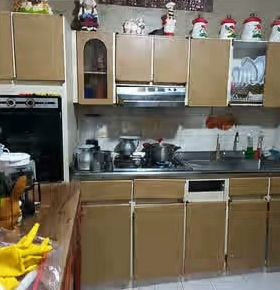 Antes: cocina antigua con gabinetes beige y mesón pequeño
