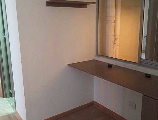 Escritorio flotante con repisa junto a una ventana